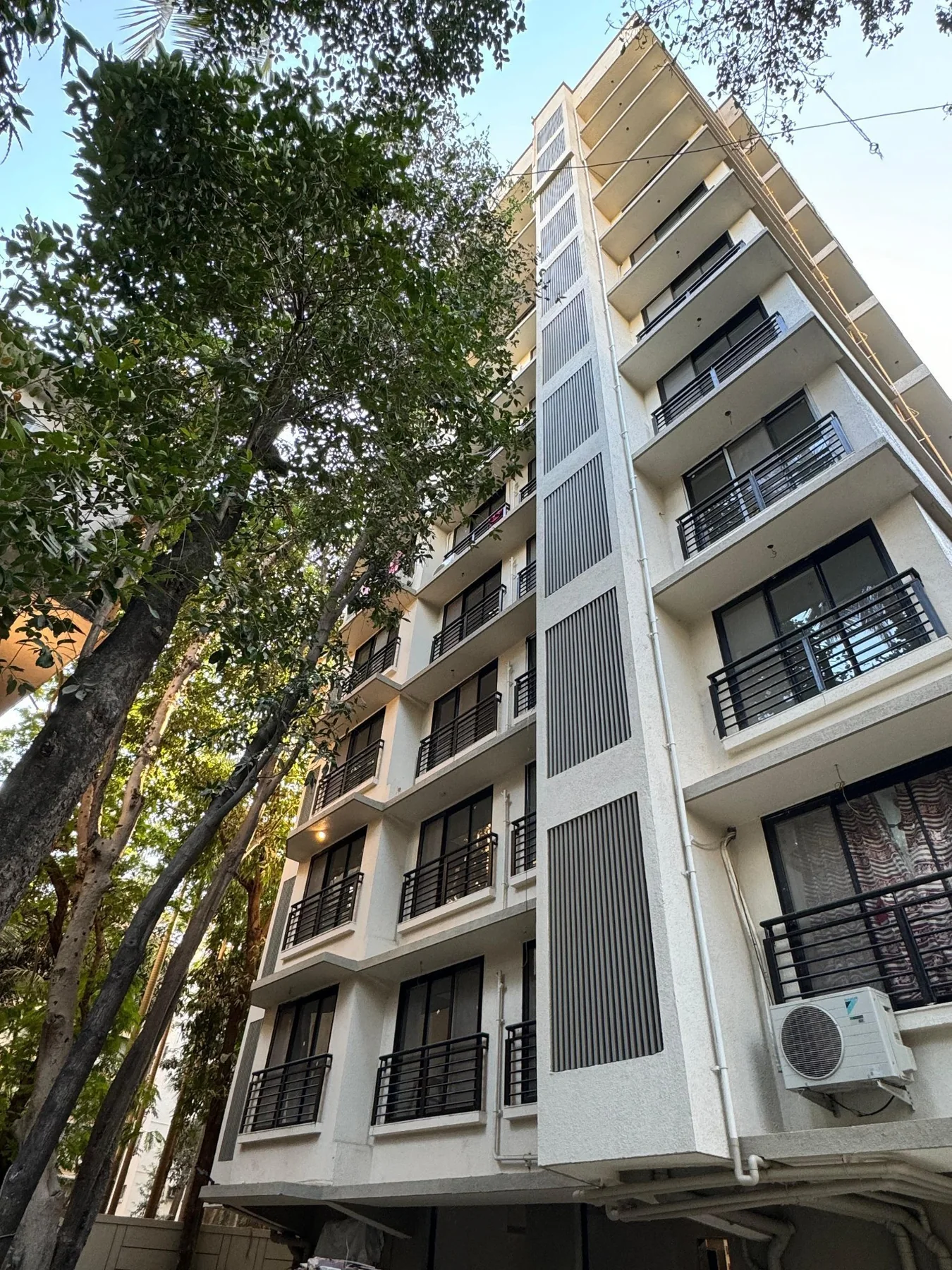 Modern multi-storey residential building with UPVC louvered utility shaft and balconies
